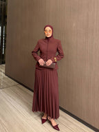 Ensemble deux pièces blazer cintré à boutons et jupe longue plissée — coupe structurée et féminine. Disponible en noir, marron et Burgundy . Livraison Partout au Canada
